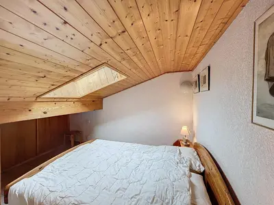 a bedroom with a bed with a wooden ceiling at Charmant 4 pièces avec terrasse face Mont Blanc, proche téléski, village et garage sécurisé - FR-1-560-133 in Combloux