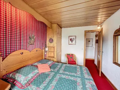 a bedroom with a bed and a red wall at Appartement 2 pièces avec parking, au pied des pistes - FR-1-560-134 in Combloux