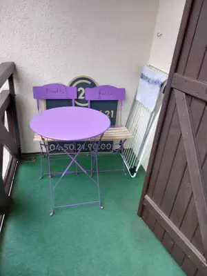 a table and two chairs sitting next to a door at Joli studio à St Gervais les bains in Saint-Gervais-les-Bains