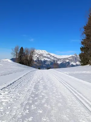 a snow covered road with mountains in the background at Joli studio à St Gervais les bains in Saint-Gervais-les-Bains