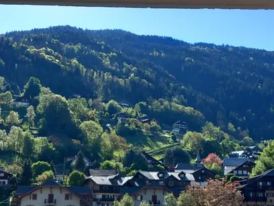 a village in the mountains with houses at Joli studio à St Gervais les bains in Saint-Gervais-les-Bains