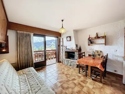 a living room with a table and a fireplace at Studio cosy au pied des pistes avec parking à Combloux - FR-1-560-137 in Combloux