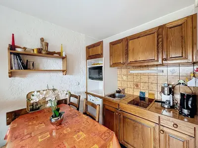 a kitchen with wooden cabinets and a wooden table at Studio cosy au pied des pistes avec parking à Combloux - FR-1-560-137 in Combloux