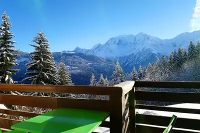 a wooden bench with a view of mountains at Studio Bettex 4p- vue Mont-Blanc in Saint-Gervais-les-Bains