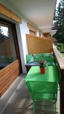 a green table with a potted plant on a balcony at Studio Bettex 4p- vue Mont-Blanc in Saint-Gervais-les-Bains