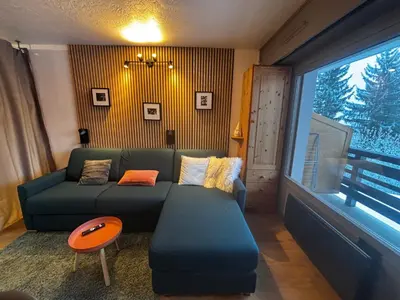 a living room with a green couch and a window at Studio Bettex 4p- vue Mont-Blanc in Saint-Gervais-les-Bains