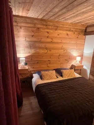 a bedroom with a wooden wall with a bed at I love Megève in Megève
