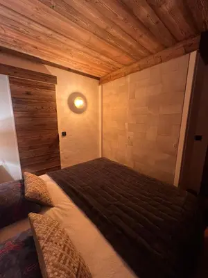 a bedroom with a bed with a wooden ceiling at I love Megève in Megève