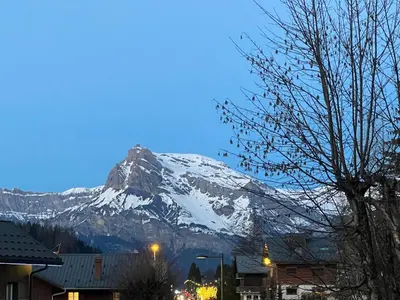 a snow covered mountain in front of a town at I love Megève in Megève