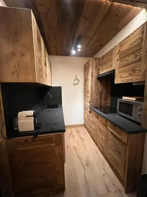 a kitchen with wooden cabinets and a black counter top at I love Megève in Megève
