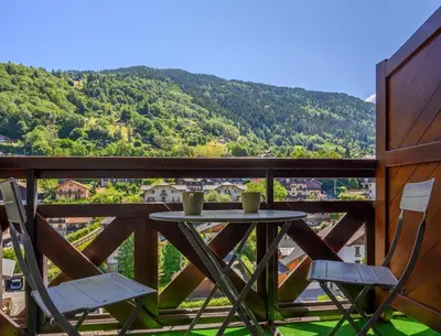 a table and chairs on a balcony with a view at Le perchoir des fées in Saint-Gervais-les-Bains