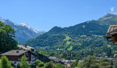a view of a town with mountains in the background at Le perchoir des fées in Saint-Gervais-les-Bains