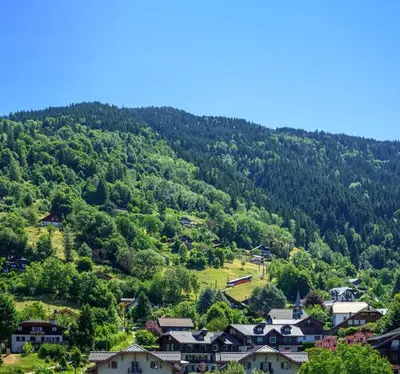 a village in the mountains with houses and trees at Le perchoir des fées in Saint-Gervais-les-Bains