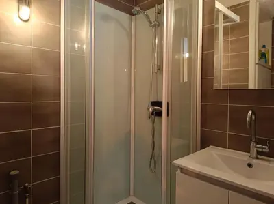 a shower with a glass door next to a sink at Le perchoir des fées in Saint-Gervais-les-Bains