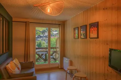 a living room with a couch and a television at Le perchoir des fées in Saint-Gervais-les-Bains