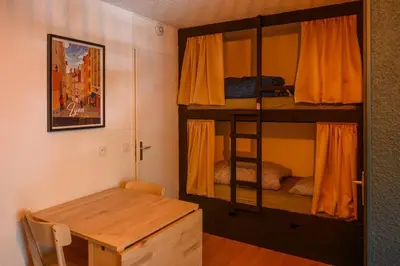 a room with a bunk bed and a wooden table at Le perchoir des fées in Saint-Gervais-les-Bains