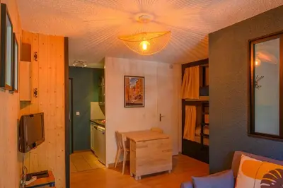 a living room with a table and a ceiling at Le perchoir des fées in Saint-Gervais-les-Bains