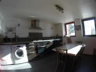 a kitchen with a washing machine and a table at Villa Jules in Chamonix-Mont-Blanc