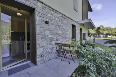 a bench sitting on a patio next to a stone wall at Appartement Samoens l'Etelley in Samoëns