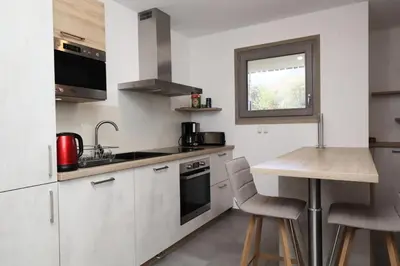 a kitchen with white cabinets and a wooden table at Résidence Hameau Des Reines - Hameau des Reines MAE-9981 in Servoz