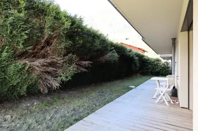 a wooden walkway with a green hedge next to a house at Résidence Hameau Des Reines - Hameau des Reines MAE-9981 in Servoz