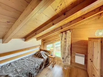 a log cabin bedroom with a bed and a window at Charmant appart 3 pièces proche des pistes avec parking et terrasse - FR-1-560-140 in Combloux