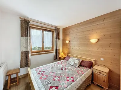 a bedroom with a bed with a quilt on it at Charmant appart 3 pièces proche des pistes avec parking et terrasse - FR-1-560-140 in Combloux