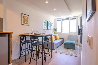 a living room with a table and a couch at Chamois Blanc Rosières- bright 1 bed apartment with amazing views in Chamonix-Mont-Blanc