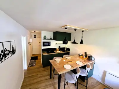 a dining room and kitchen with a table and chairs at Appart Les Cosmiques, Vue Mont Blanc - Aiguille du Midi in Chamonix-Mont-Blanc