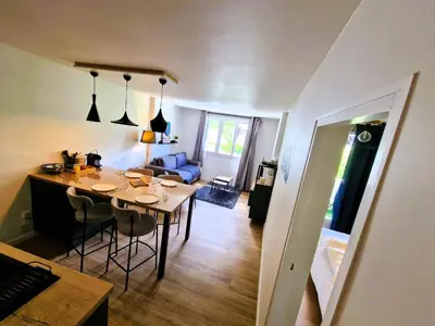 a kitchen and living room with a table and chairs at Appart Les Cosmiques, Vue Mont Blanc - Aiguille du Midi in Chamonix-Mont-Blanc