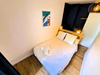 a small bedroom with a bed with two pillows at Appart Les Cosmiques, Vue Mont Blanc - Aiguille du Midi in Chamonix-Mont-Blanc