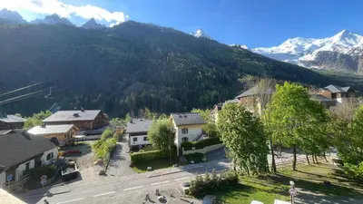 an aerial view of a town with a mountain at Appart Les Cosmiques, Vue Mont Blanc - Aiguille du Midi in Chamonix-Mont-Blanc
