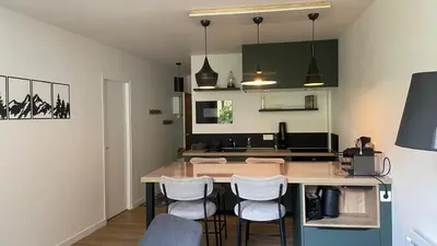 a kitchen with a table and chairs in a room at Appart Les Cosmiques, Vue Mont Blanc - Aiguille du Midi in Chamonix-Mont-Blanc