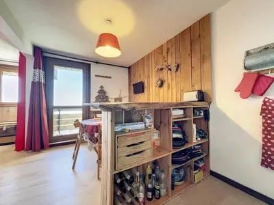 a room with a table and a shelf with wine bottles at Studio Samoëns 1600 station de ski in Samoëns