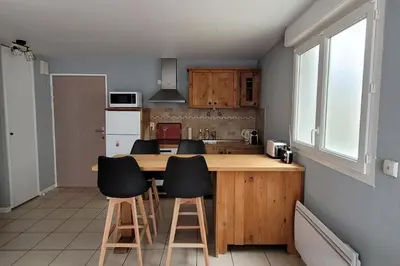 a kitchen with a wooden counter and stools at Appartement l'Étoile pour 1 à 4 personnes in Sallanches