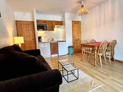 a living room with a table and a kitchen at Studio confortable avec parking et animaux admis - FR-1-629-139 in Samoëns