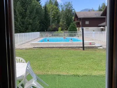 a view of a swimming pool from a window at Studio confortable avec parking et animaux admis - FR-1-629-139 in Samoëns