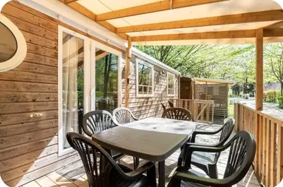 a patio with a table and chairs on a deck at MH F4 Ski Rando Loisirs Proche Chamonix 6 pers 300AK in Passy