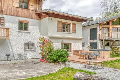 a home with a wooden deck and a patio at Appartement de Luxe avec Jacuzzi, Vue Montagne et Jardin in Chamonix-Mont-Blanc