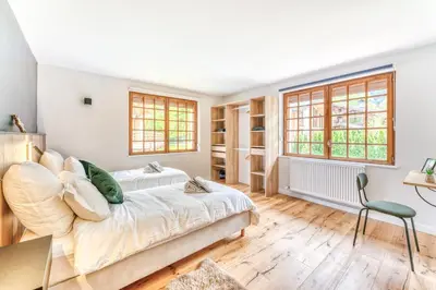 a bedroom with a bed and a desk and a window at Appartement de Luxe avec Jacuzzi, Vue Montagne et Jardin in Chamonix-Mont-Blanc
