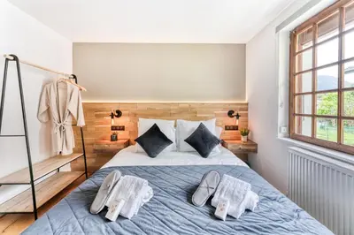 a bedroom with a bed with slippers on it at Appartement de Luxe avec Jacuzzi, Vue Montagne et Jardin in Chamonix-Mont-Blanc