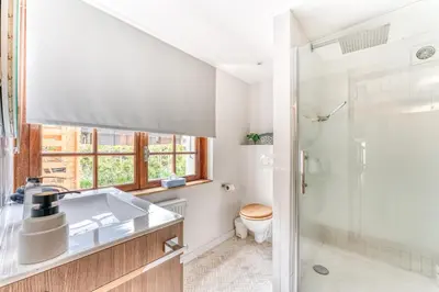 a bathroom with a sink and a toilet and a shower at Appartement de Luxe avec Jacuzzi, Vue Montagne et Jardin in Chamonix-Mont-Blanc