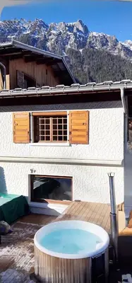 a building with a table in front of it at Appartement de Luxe avec Jacuzzi, Vue Montagne et Jardin in Chamonix-Mont-Blanc