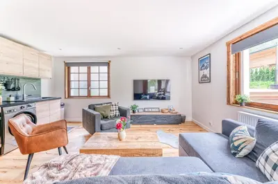 a living room with a couch and a table at Appartement de Luxe avec Jacuzzi, Vue Montagne et Jardin in Chamonix-Mont-Blanc