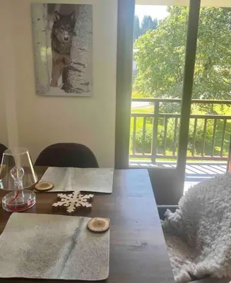 a dining room table with a picture of a cat on the wall at Appartement à Megève in Demi-Quartier