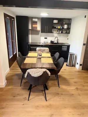 a dining room with a table and chairs and a kitchen at Appartement à Megève in Demi-Quartier
