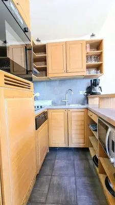 a kitchen with wooden cabinets and a sink at Résidence Les Terrasses D'eos - Appartement spacieux · Accès direct aux pistes · Piscine · WIFI gratuit et illimité · Spa MAE-1661 in Magland
