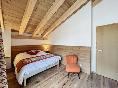 a bedroom with a bed and a chair at Appartement de Standing 4 Chambres au Pied des Pistes à Combloux - FR-1-560-122 in Combloux