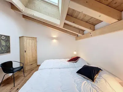 a bedroom with a bed and a chair in it at Appartement de Standing 4 Chambres au Pied des Pistes à Combloux - FR-1-560-122 in Combloux