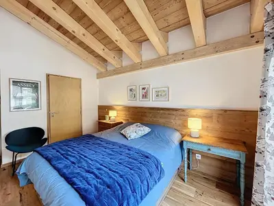 a bedroom with a bed with a blue comforter at Appartement de Standing 4 Chambres au Pied des Pistes à Combloux - FR-1-560-122 in Combloux